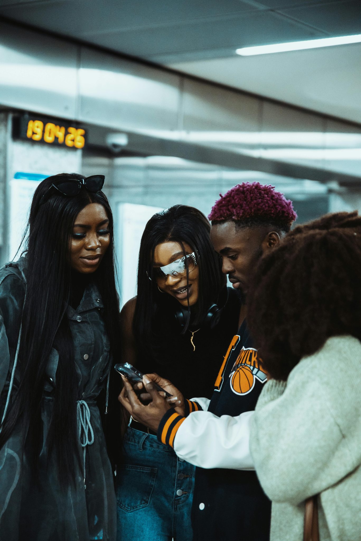 Young friends gathered at a station, sharing a smartphone moment and enjoying each other's company.