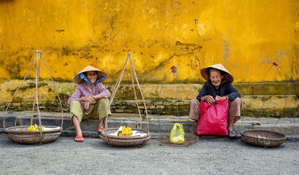 Vibrant scene of elderly street vendors in Hội An, Vietnam.