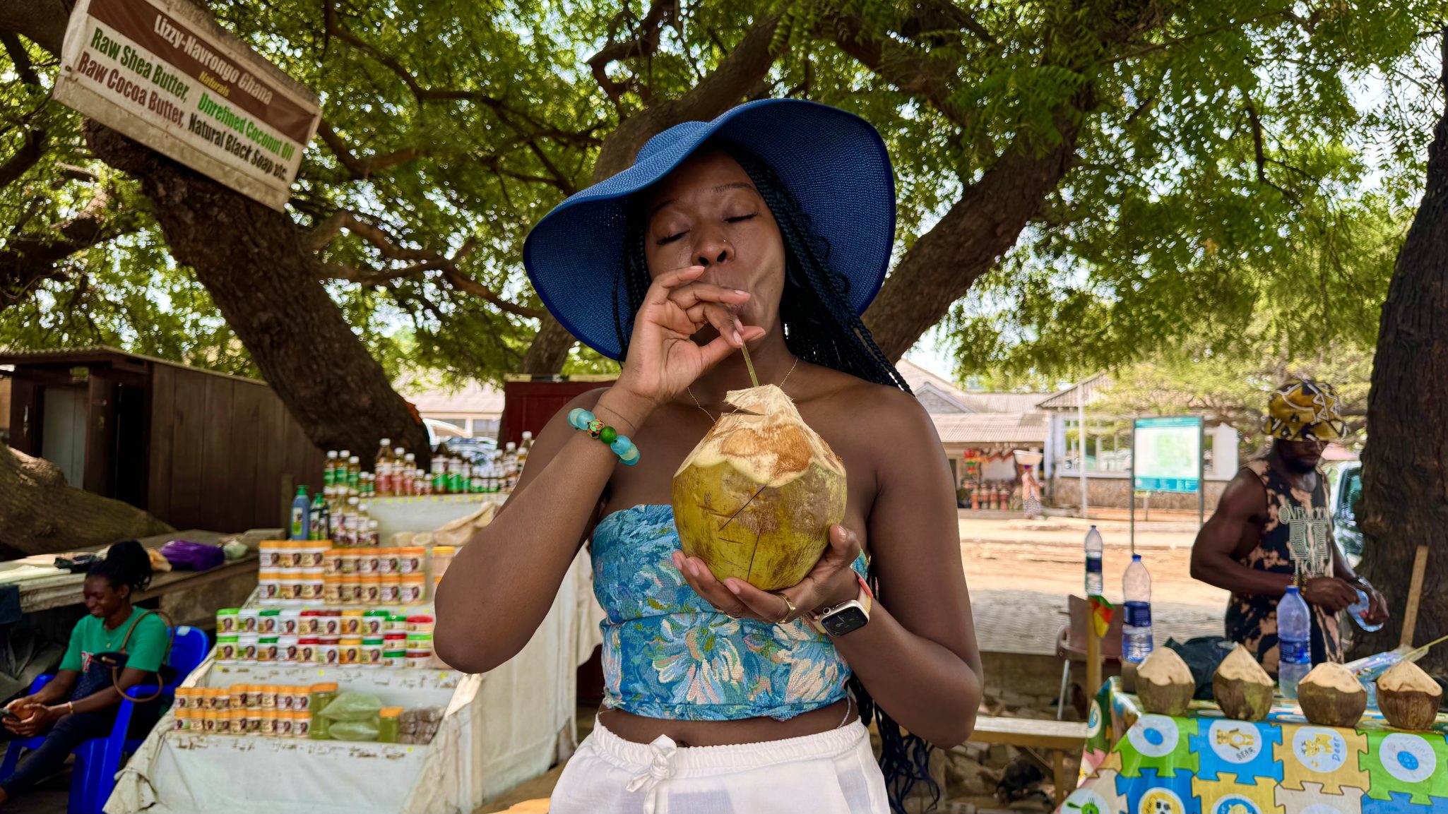 Accra Ghana, sipping on a coconut water with a straw under a tree