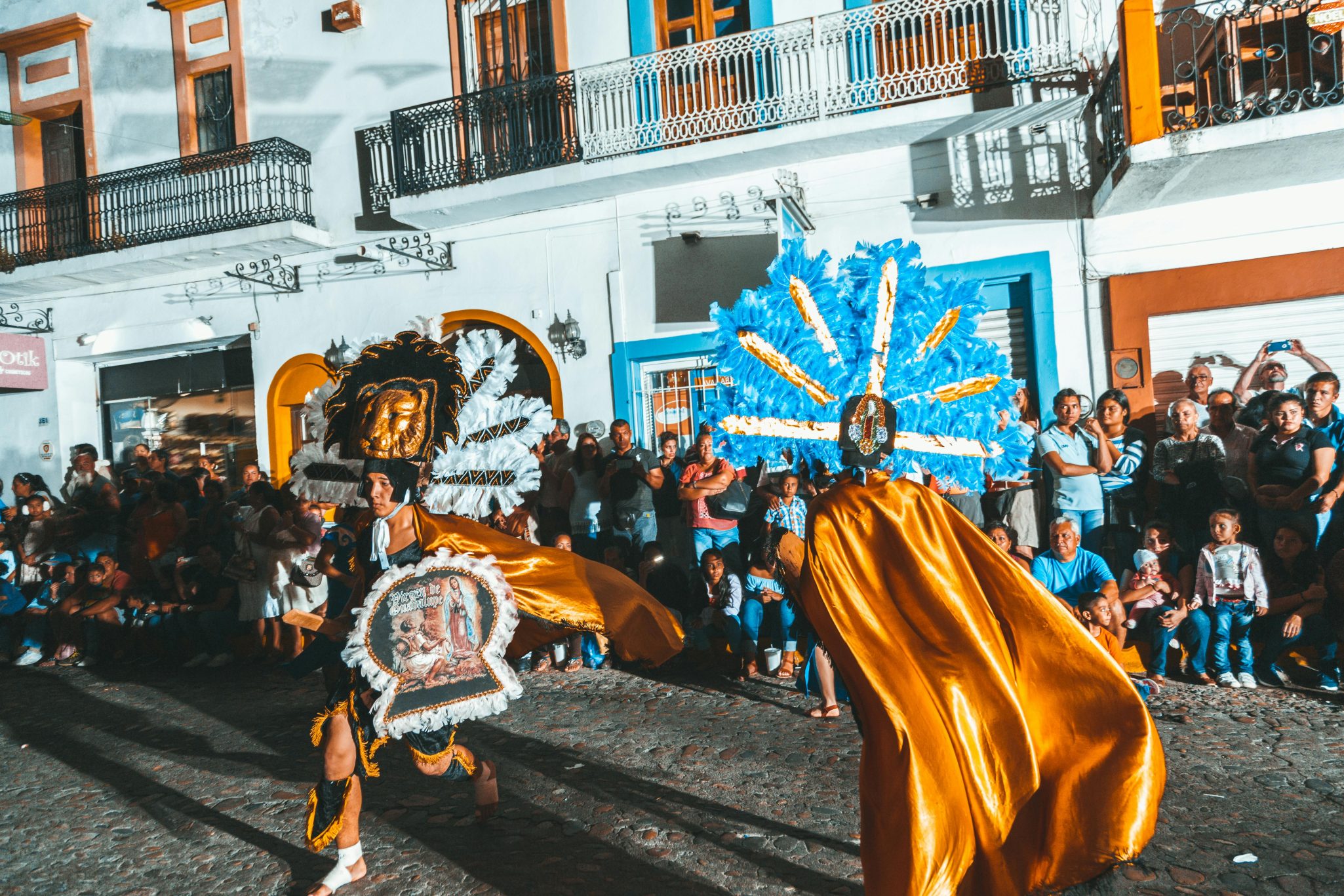 Vibrant street parade with colorful costumes and dancers in Puerto Vallarta, Mexico.