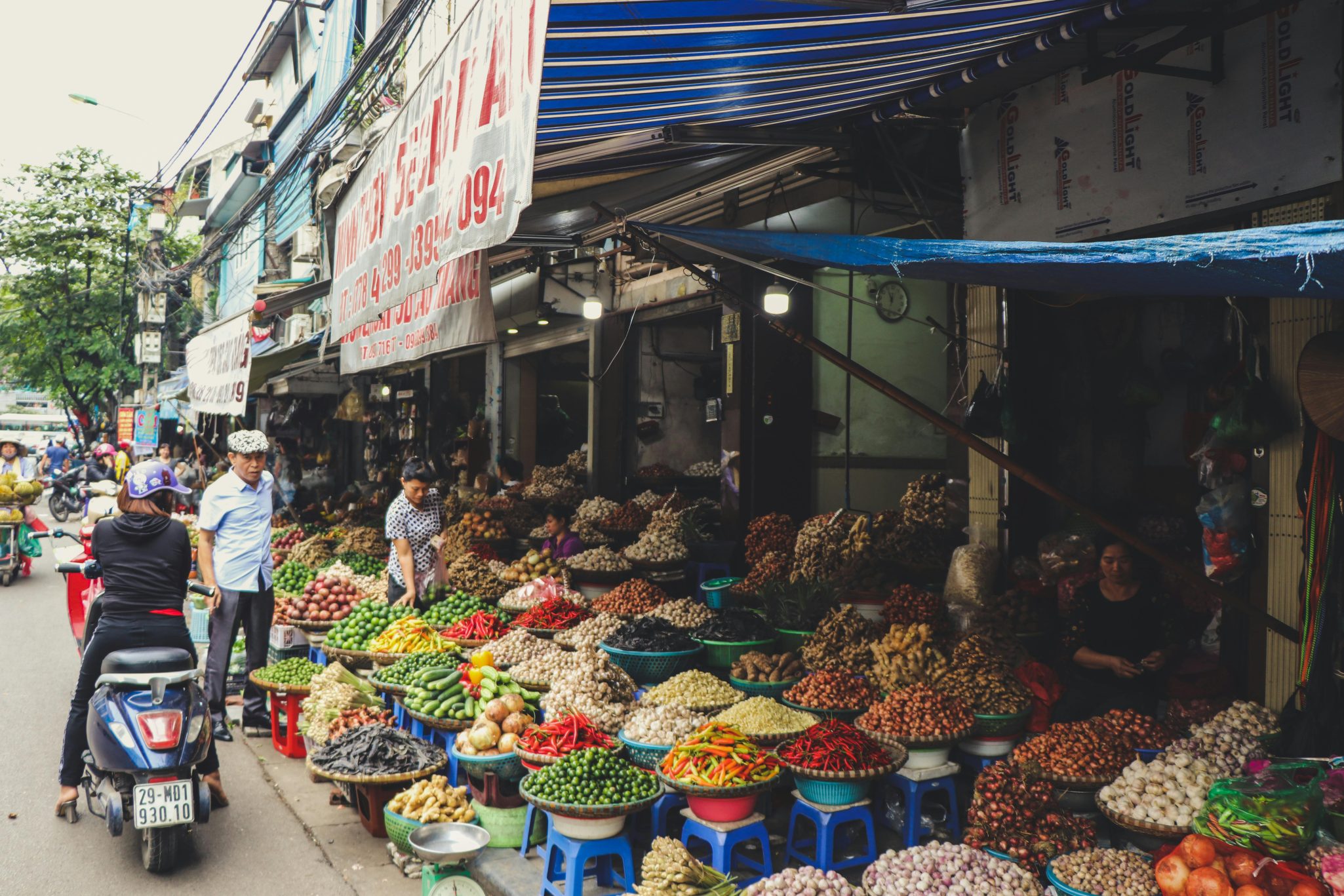 Outdoor street market in Hanoi featuring colorful produce and local vendors.