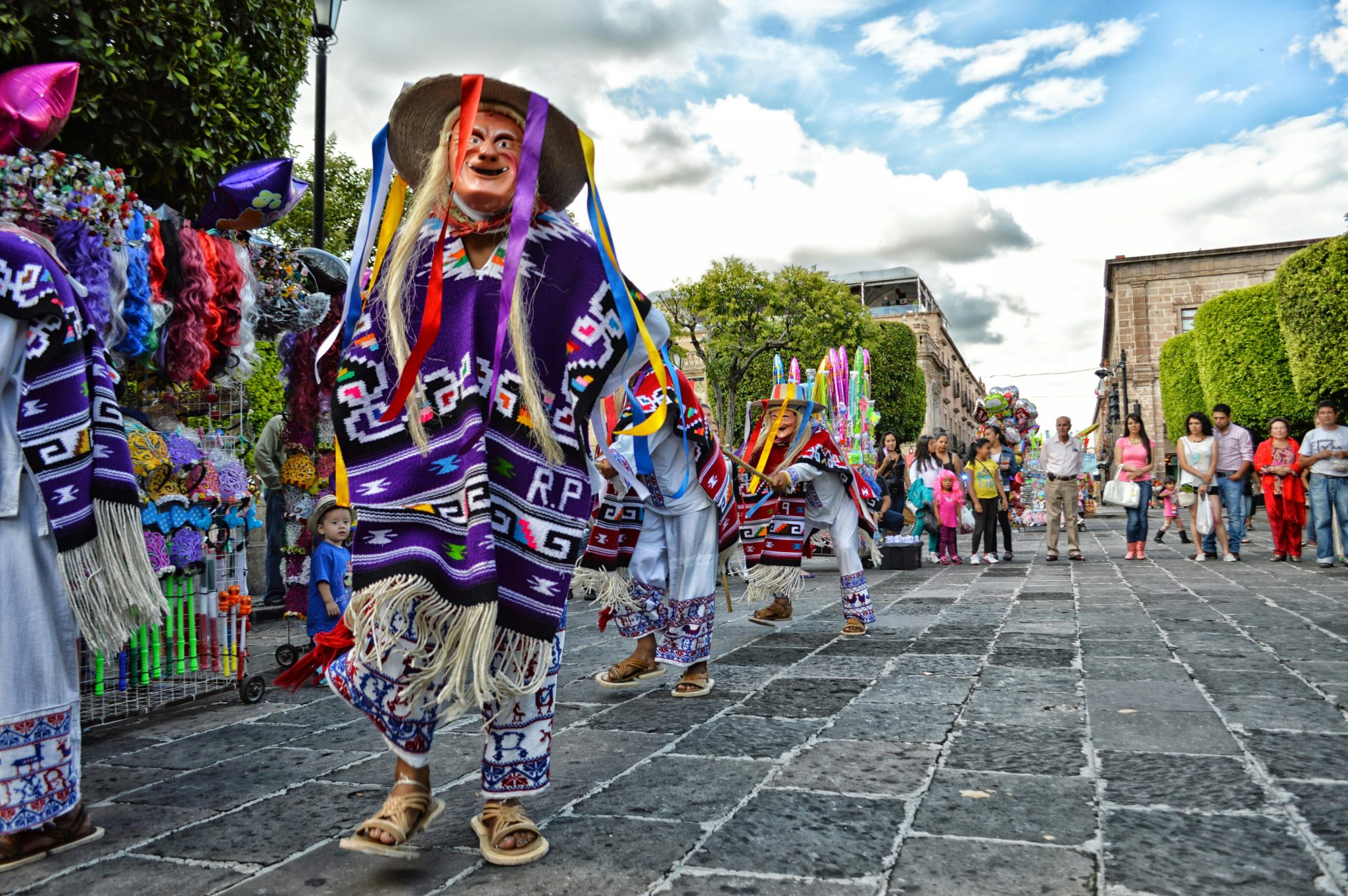 Colorful street parade in Mexico showcasing traditional costumes and cultural celebration.