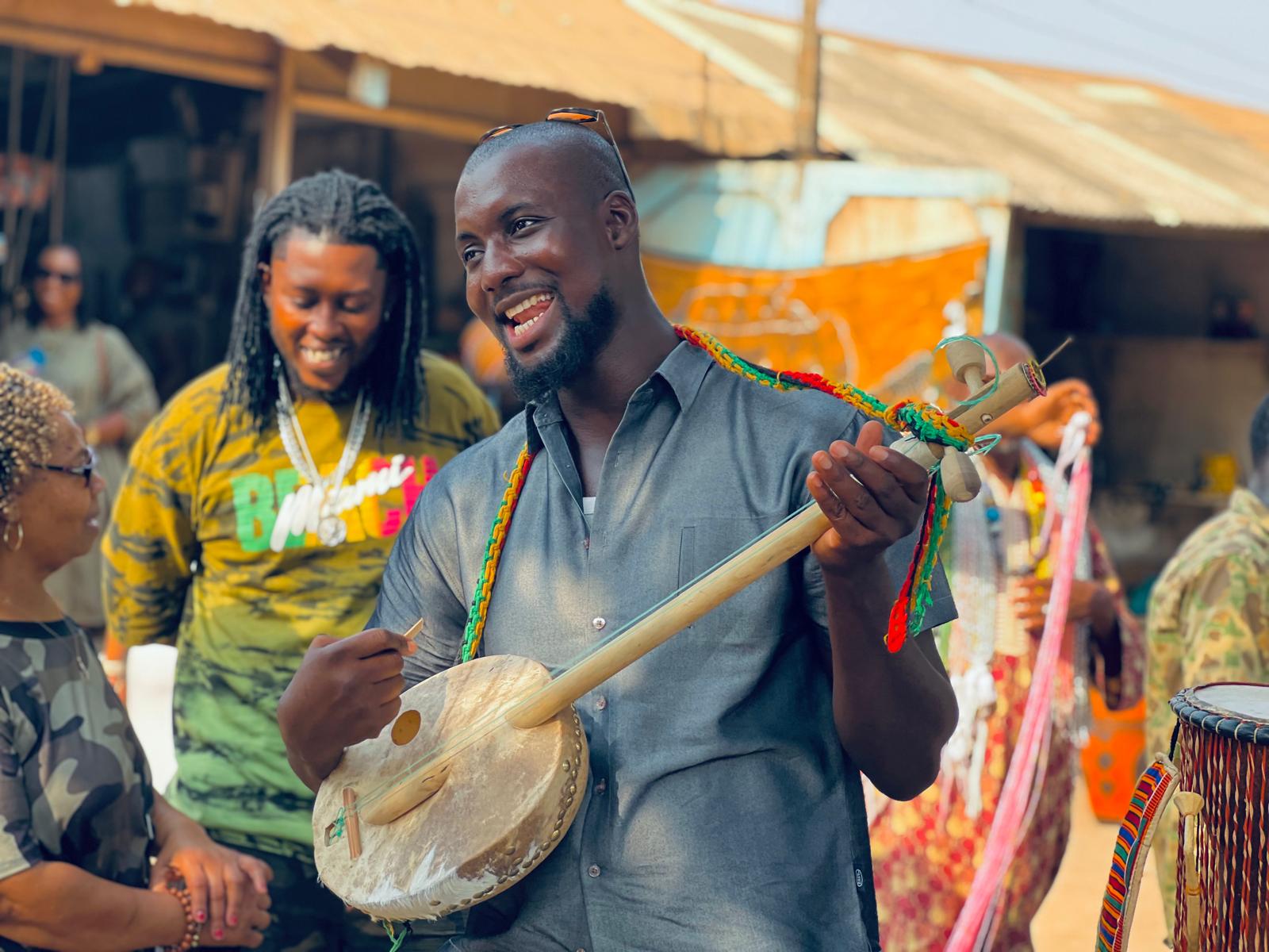 Philip Saforo in Ghana PLaying African banjo-like instrument in a group setting