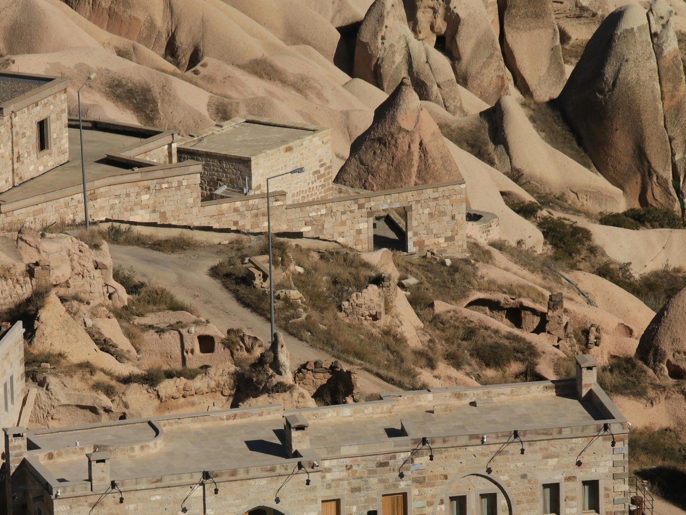 Stunning aerial view of a cave hotel set among the iconic rock formations in Cappadocia, Turkey.
