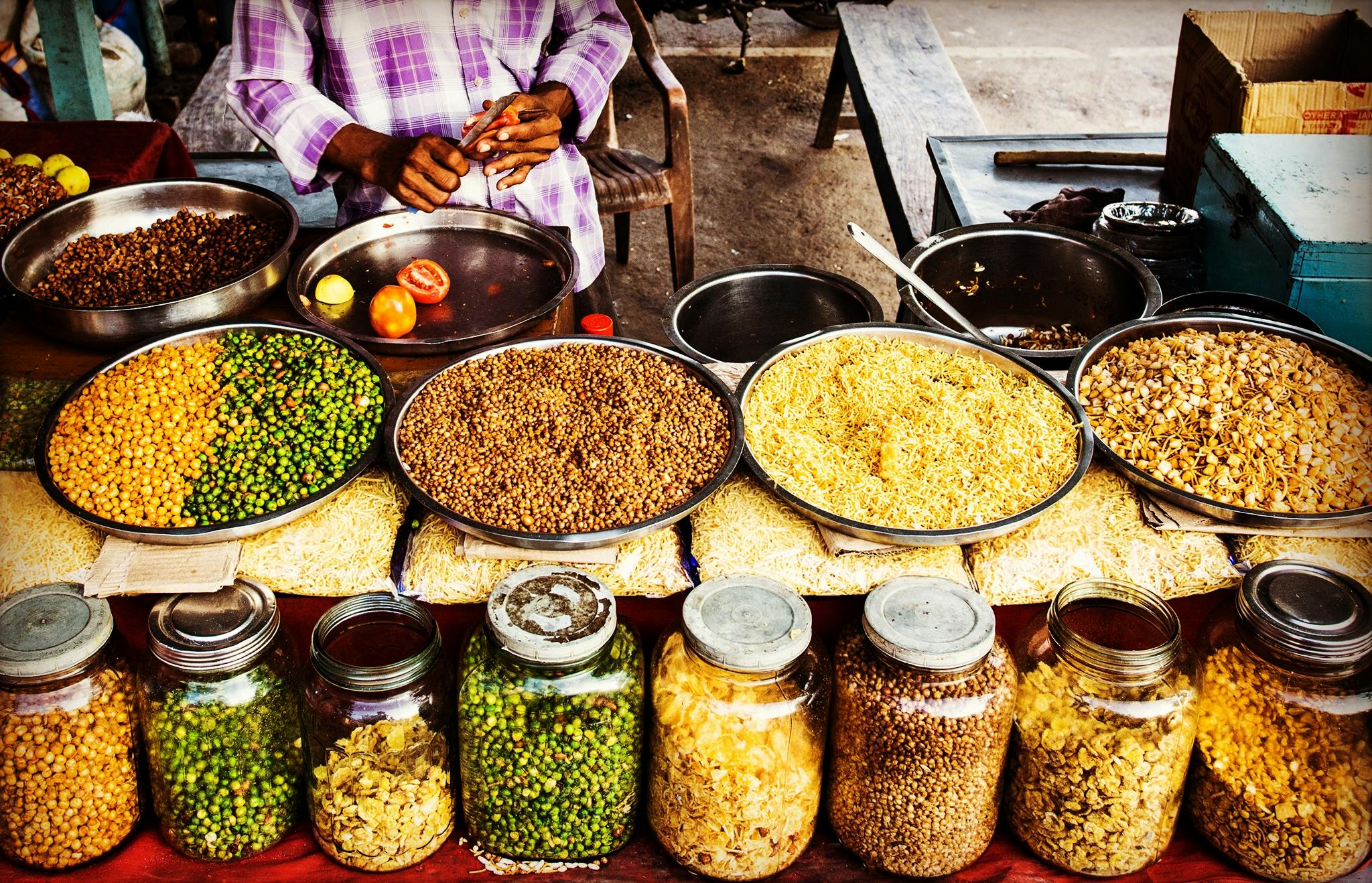 Colorful display of spices and legumes in a traditional Indian street market.