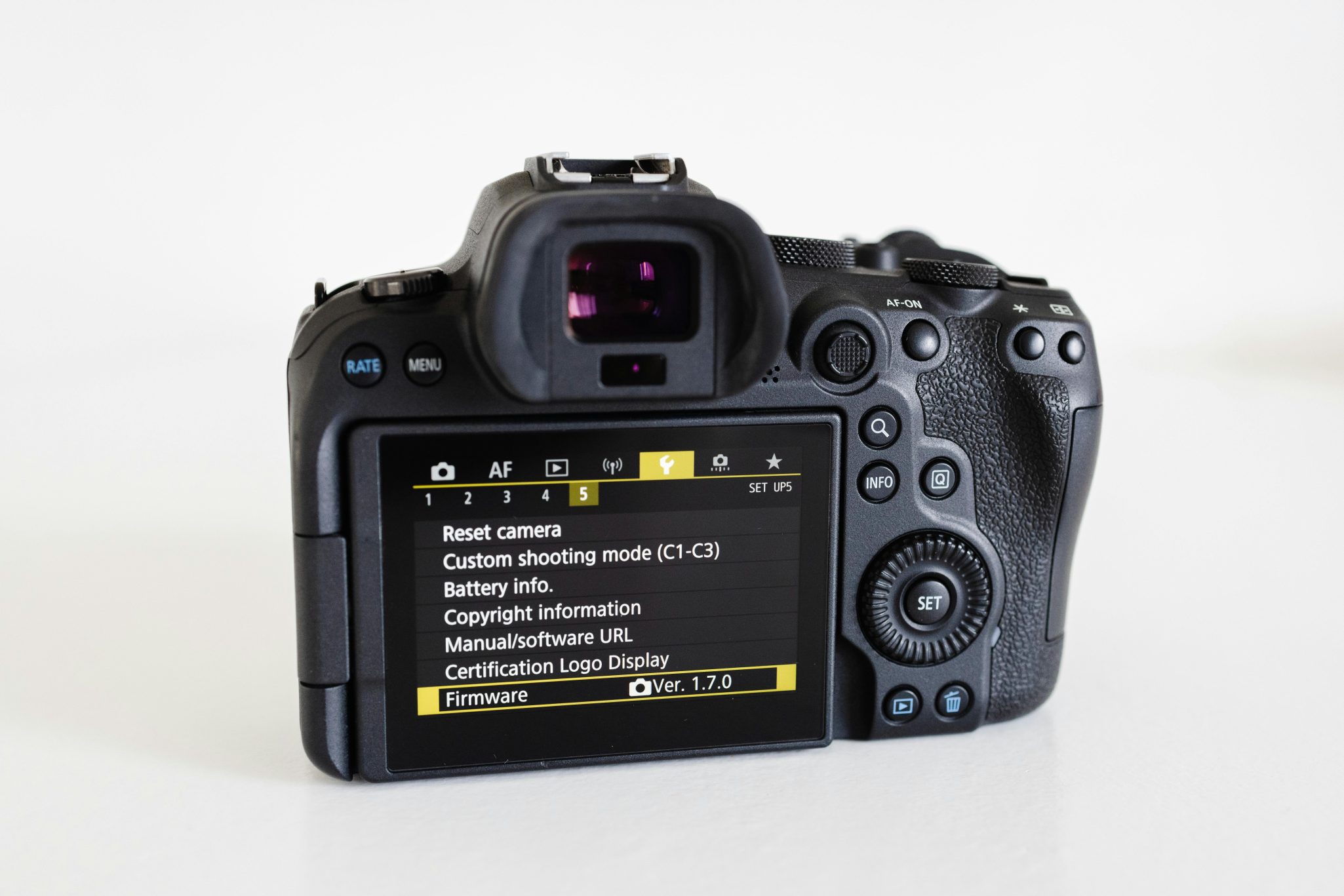 Close-up of a camera with a visible digital screen showcasing settings on a white background.