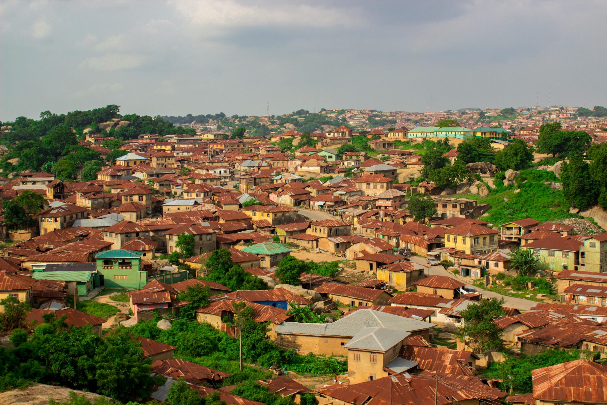 Aerial view of rustic rooftops in Abeokuta, Nigeria with greenery.