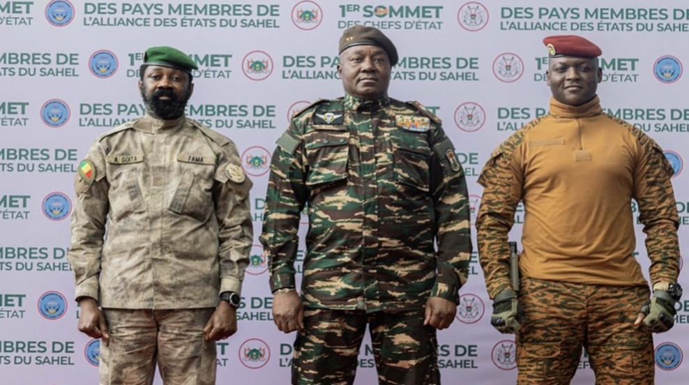 Leaders of Mali, Burkina Faso, and Niger standing together at the Alliance of Sahel States summit, showcasing military representatives in uniforms, with a backdrop highlighting their collaboration.