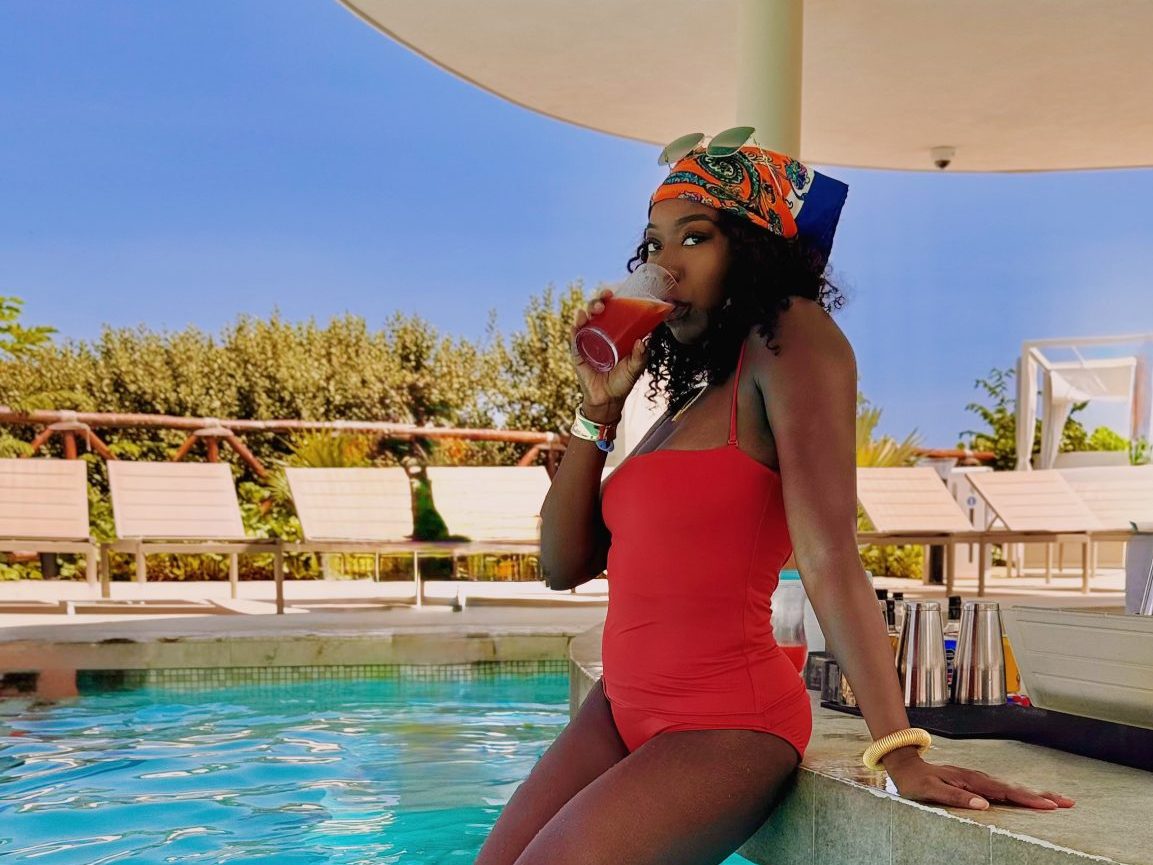 Girl in a orange bathing suit sitting on a pool bar