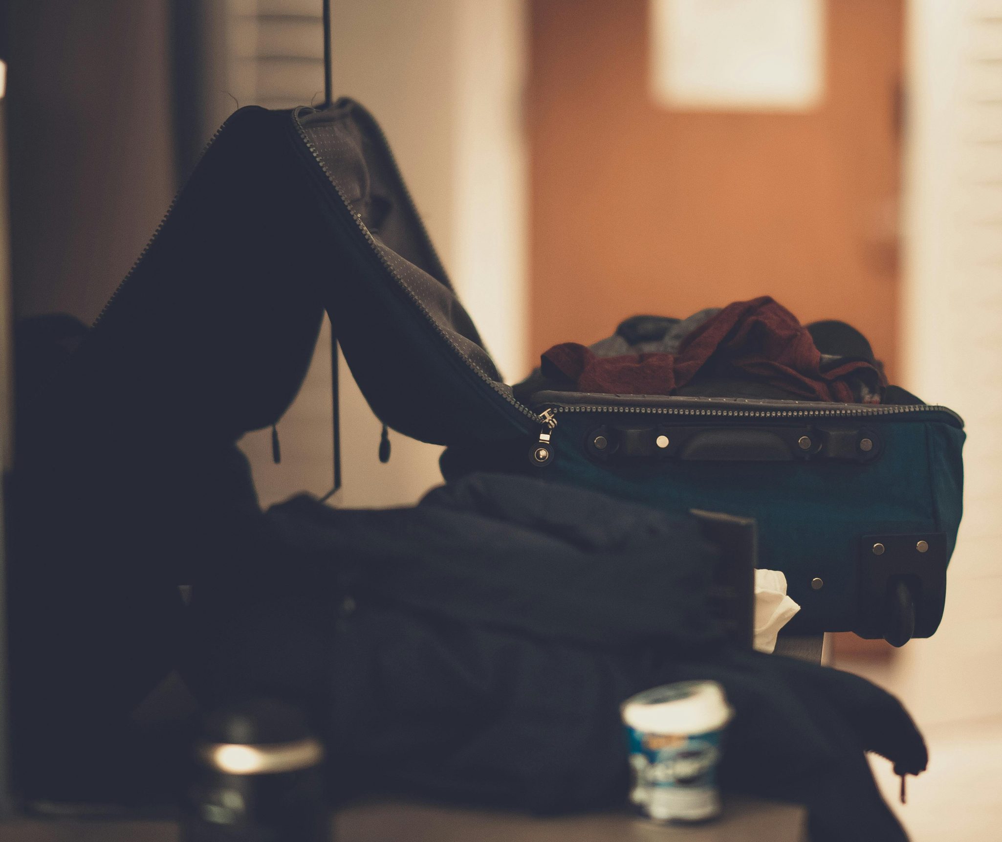 A warm-toned indoor image of an open suitcase with clothes, conveying travel readiness.